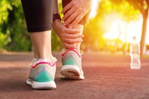 Runner clutching painful ankle